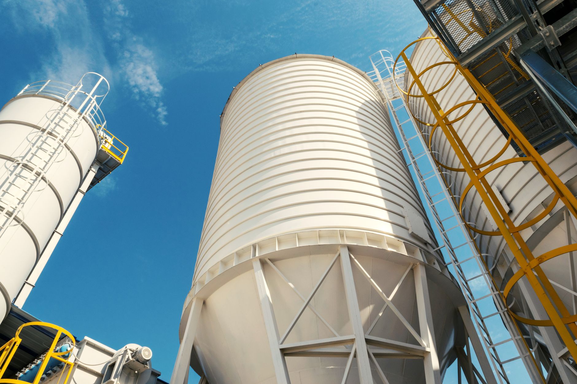 Industrial silos against a clear blue sky, showcasing high-quality construction and design.